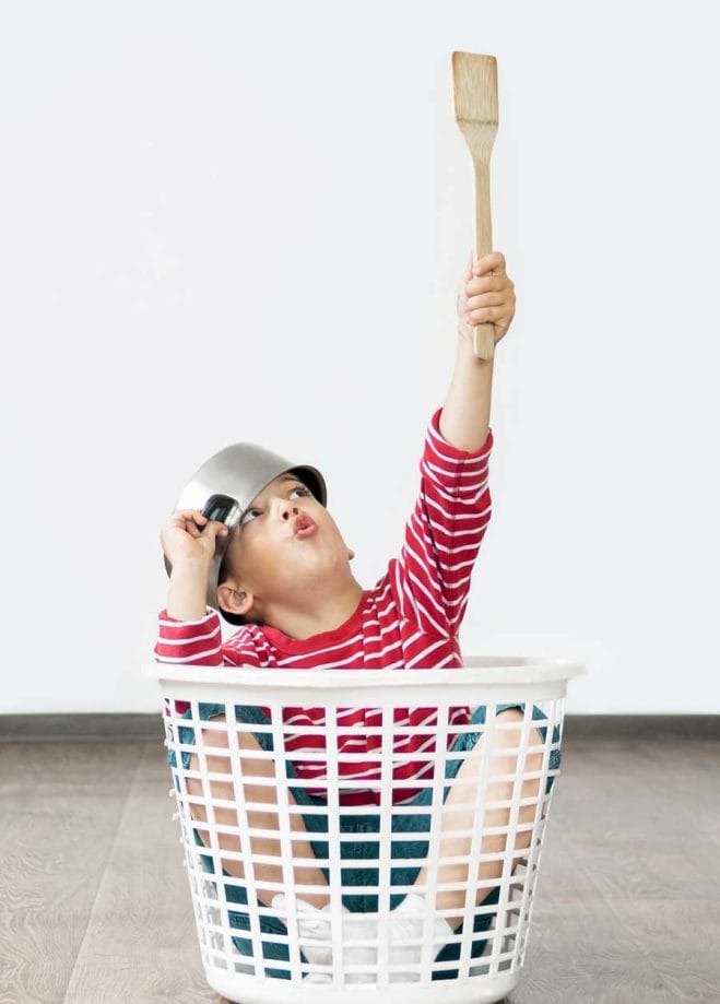 Boy sitting in laundry basket