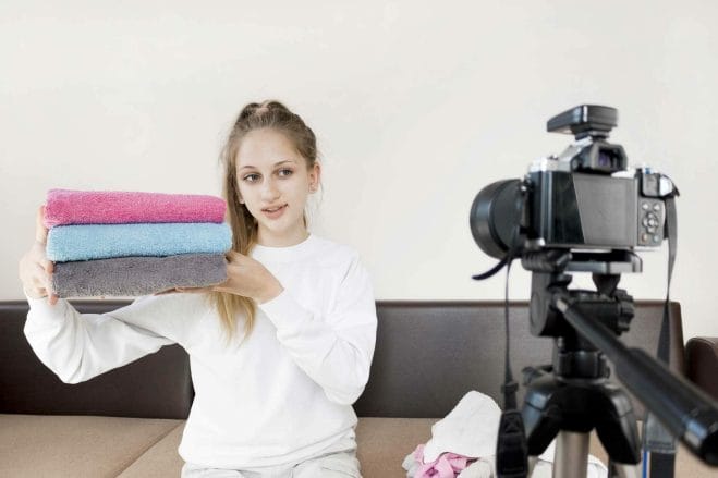 Medium shot girl folding towels home