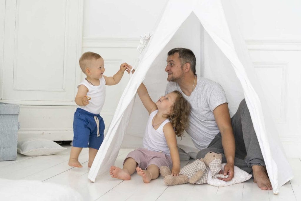 full shot father playing with kids