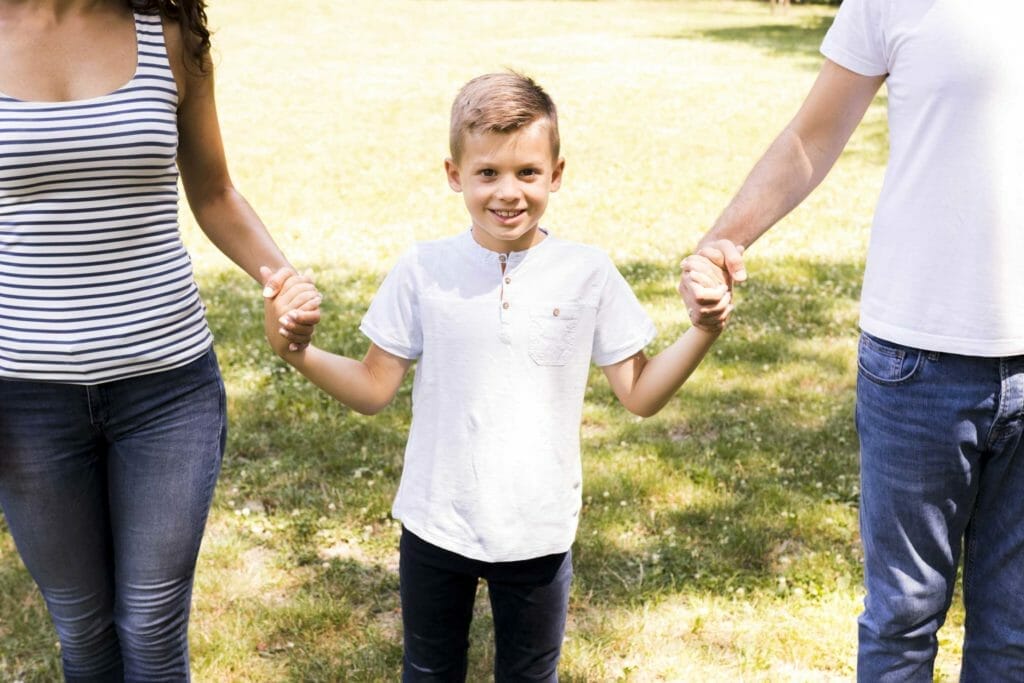 happy kid holding his parents hands