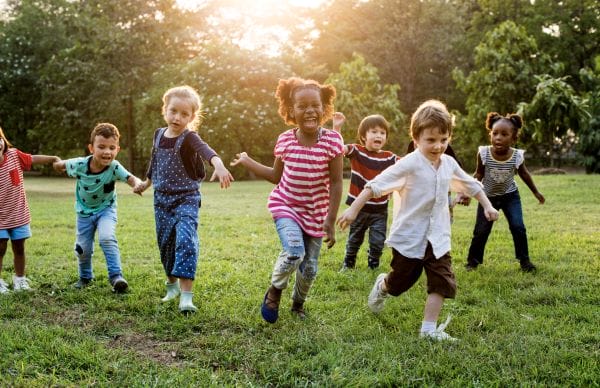 Group diverse kids playing field together