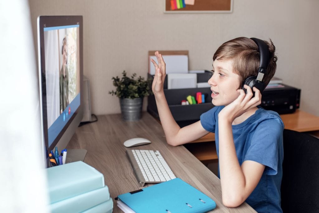 teenage boy communicates with relatives via a web camera video conference