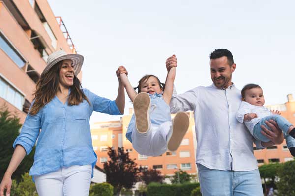 600 happy hispanic couple lifting daughter outdoors