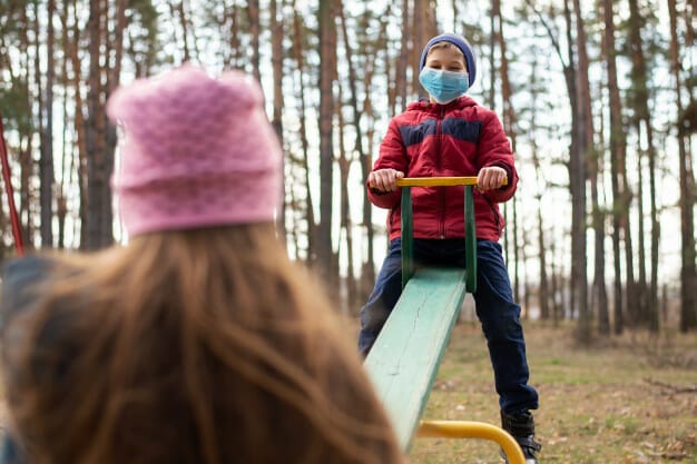 boy girl medical masks swinging swing playground