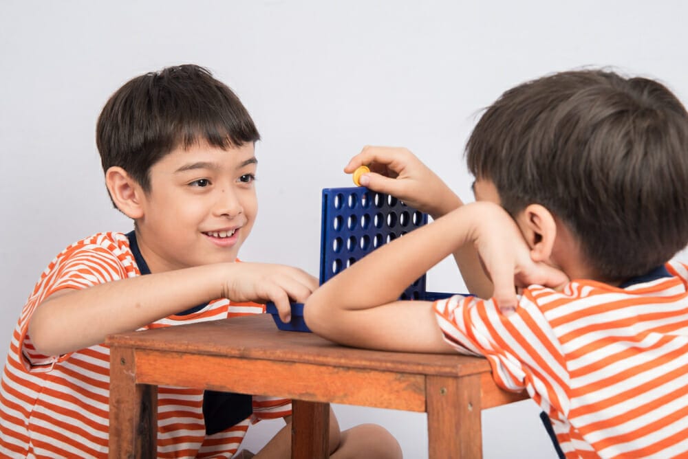 little boy playin connect four game soft focus eye contact