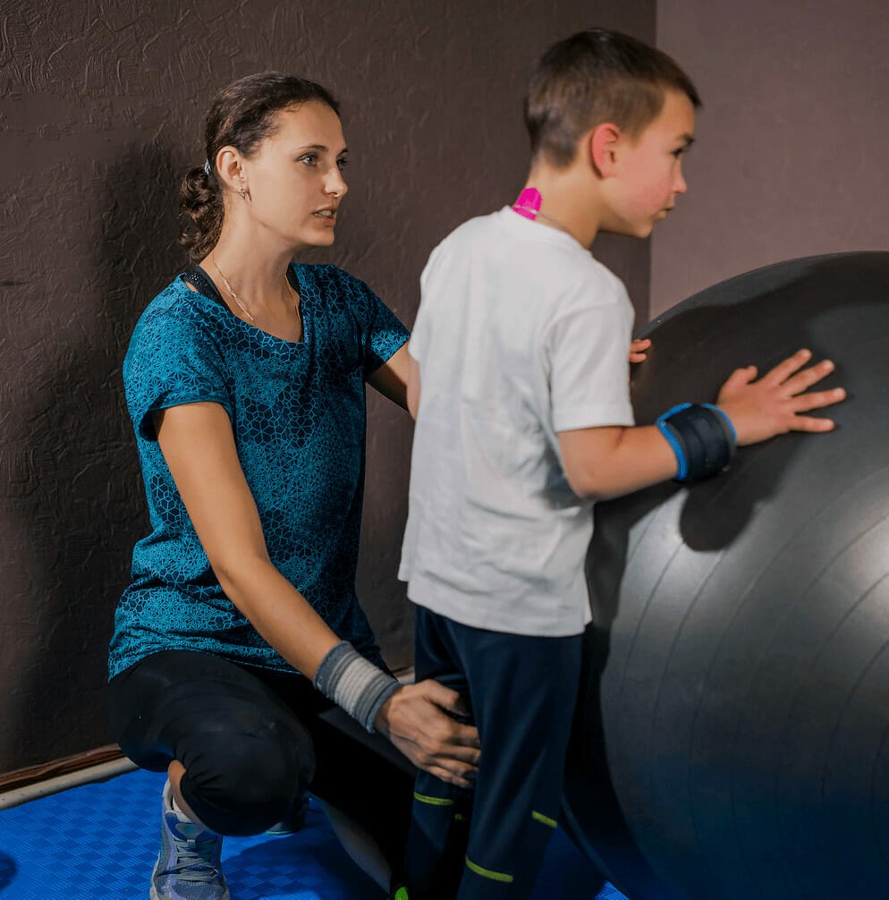 Laughing kids with smartphone sitting on fitness balls