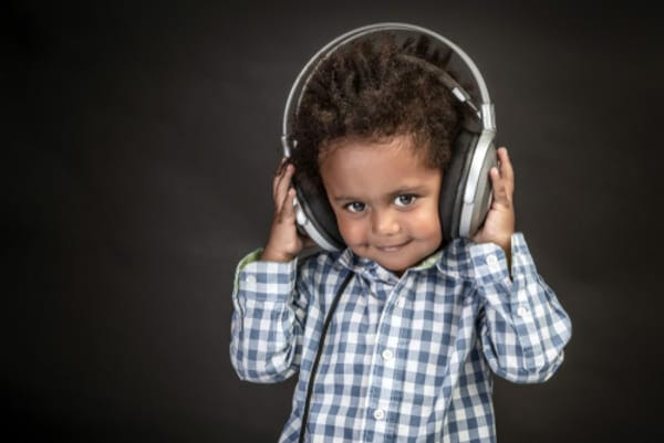 Little boy wears big headphones is a photograph