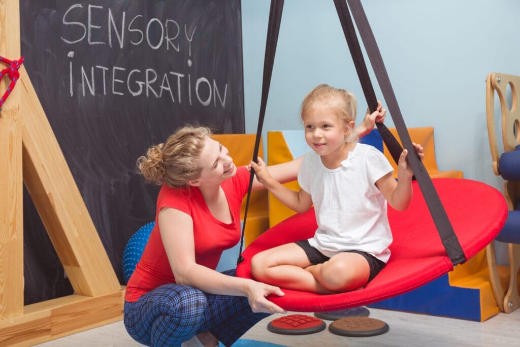 A shot of a smiling girl enjoying a sensory therapy session.